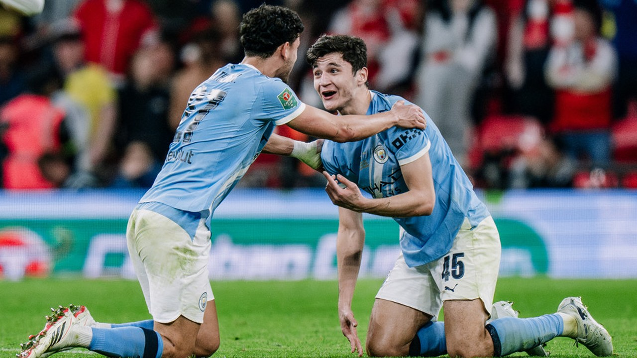 Abdukodir Khusanov celebrates on his knees with a Manchester City teammate
