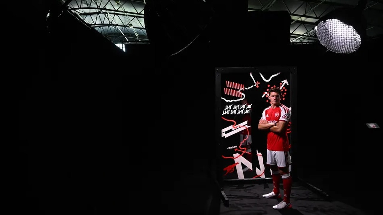 Christos Tzolis stands in an Arsenal shirt at the Emirates Stadium