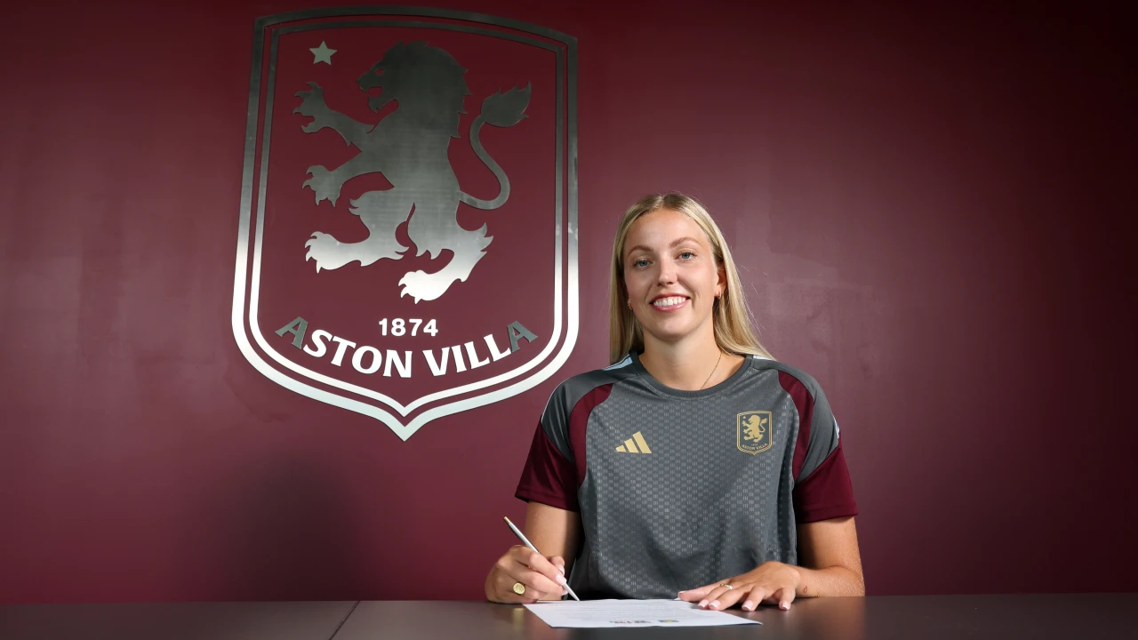 Emily Ramsey signing her Aston Villa contract beside the club crest