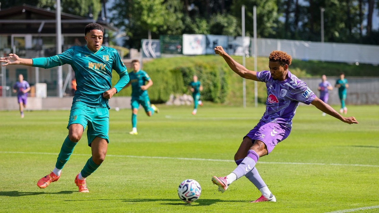 Bournemouth and Augsburg players challenge for the ball on the pitch