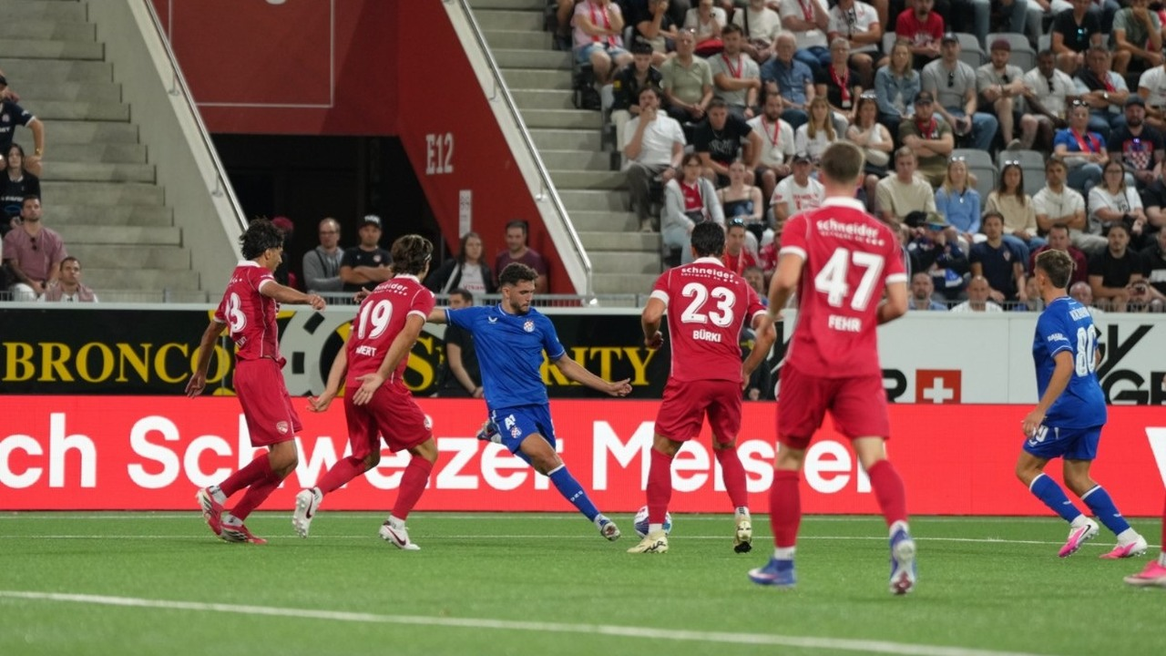 Football players celebrate together beside the goal