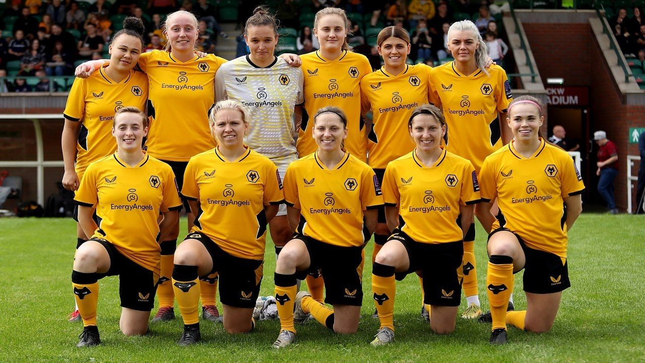 Wolverhampton Wanderers Women pose together on a football pitch