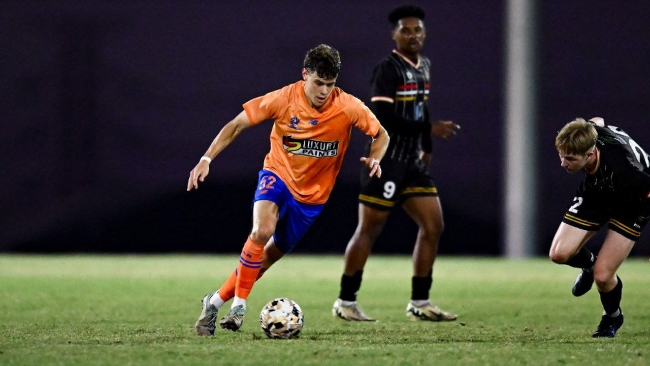 A Young Roar player carries the ball in an NPL match