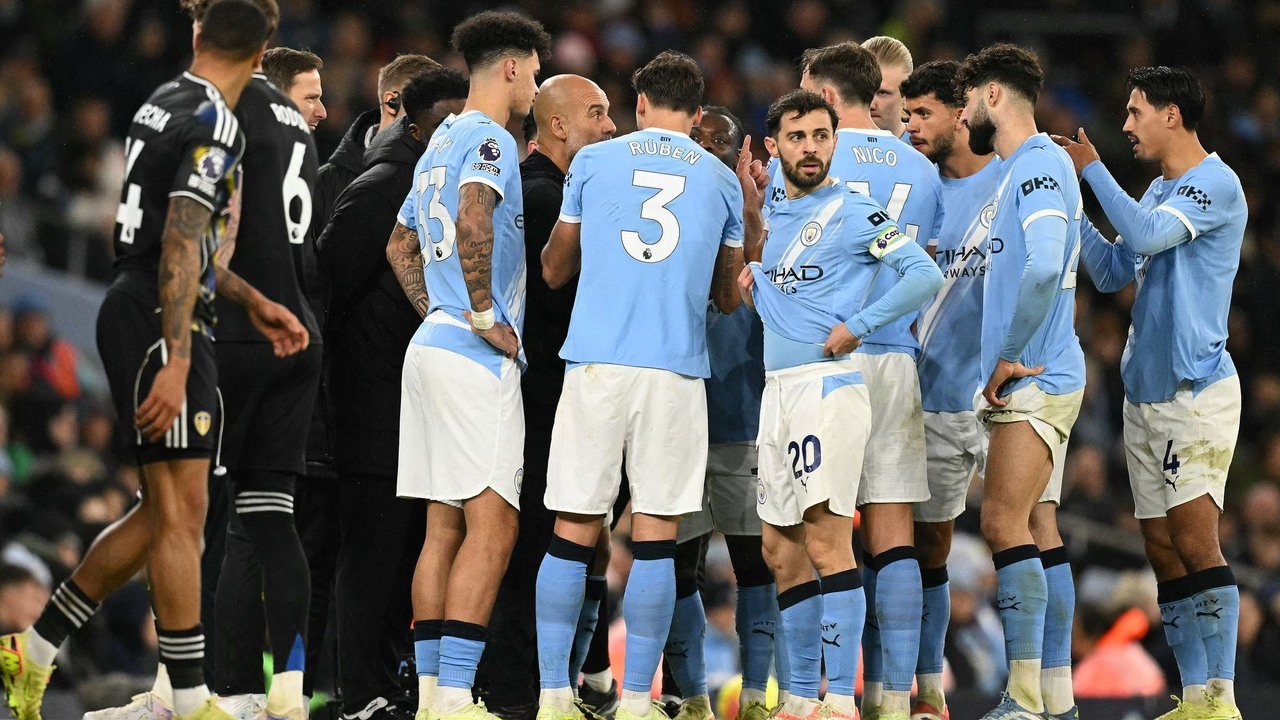 Manchester City players gather beside the technical area during a stoppage