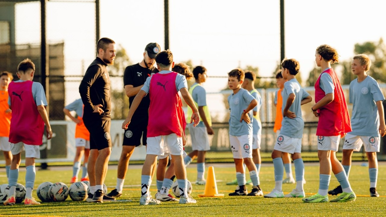 Melbourne City academy players train with footballs on an outdoor pitch