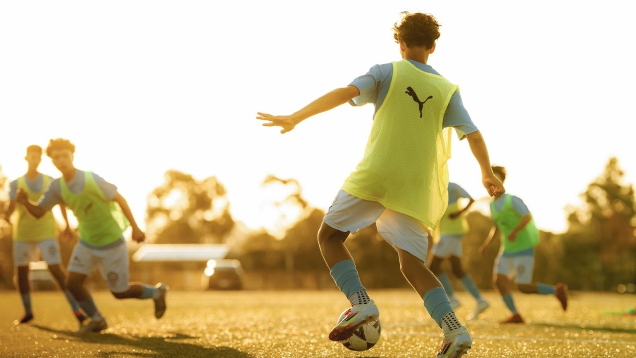 Melbourne City academy players take part in a training game at sunset