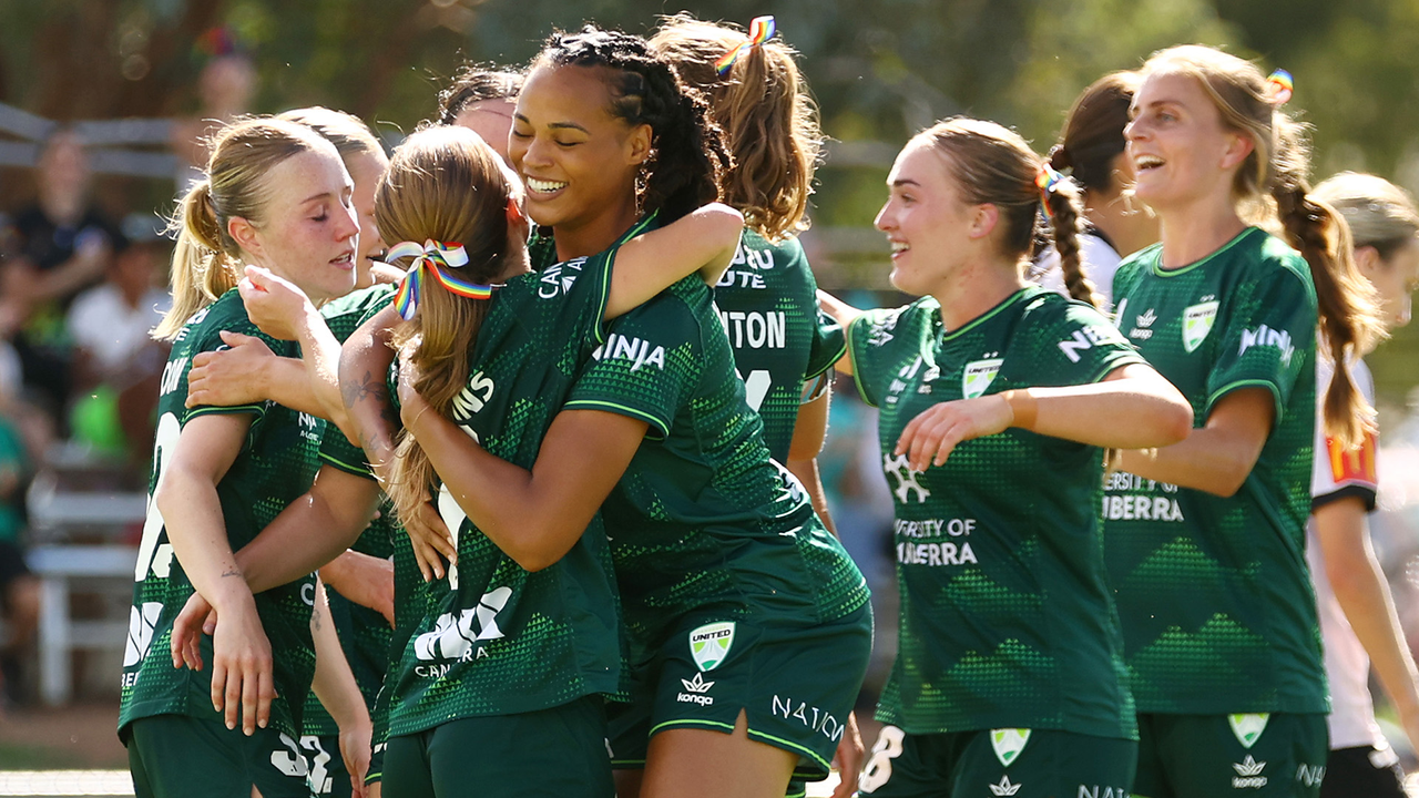 Canberra United players celebrate together in the club's green kit