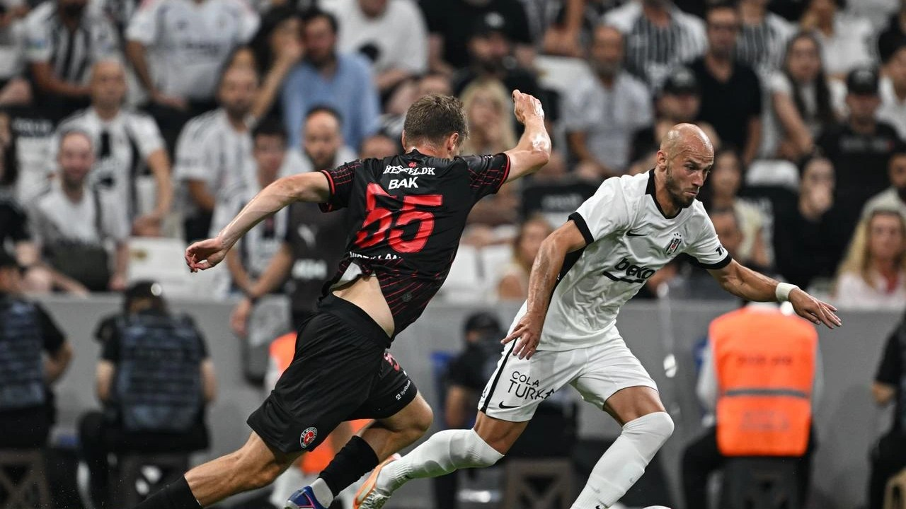 A Beşiktaş player dribbles past a Midtjylland opponent