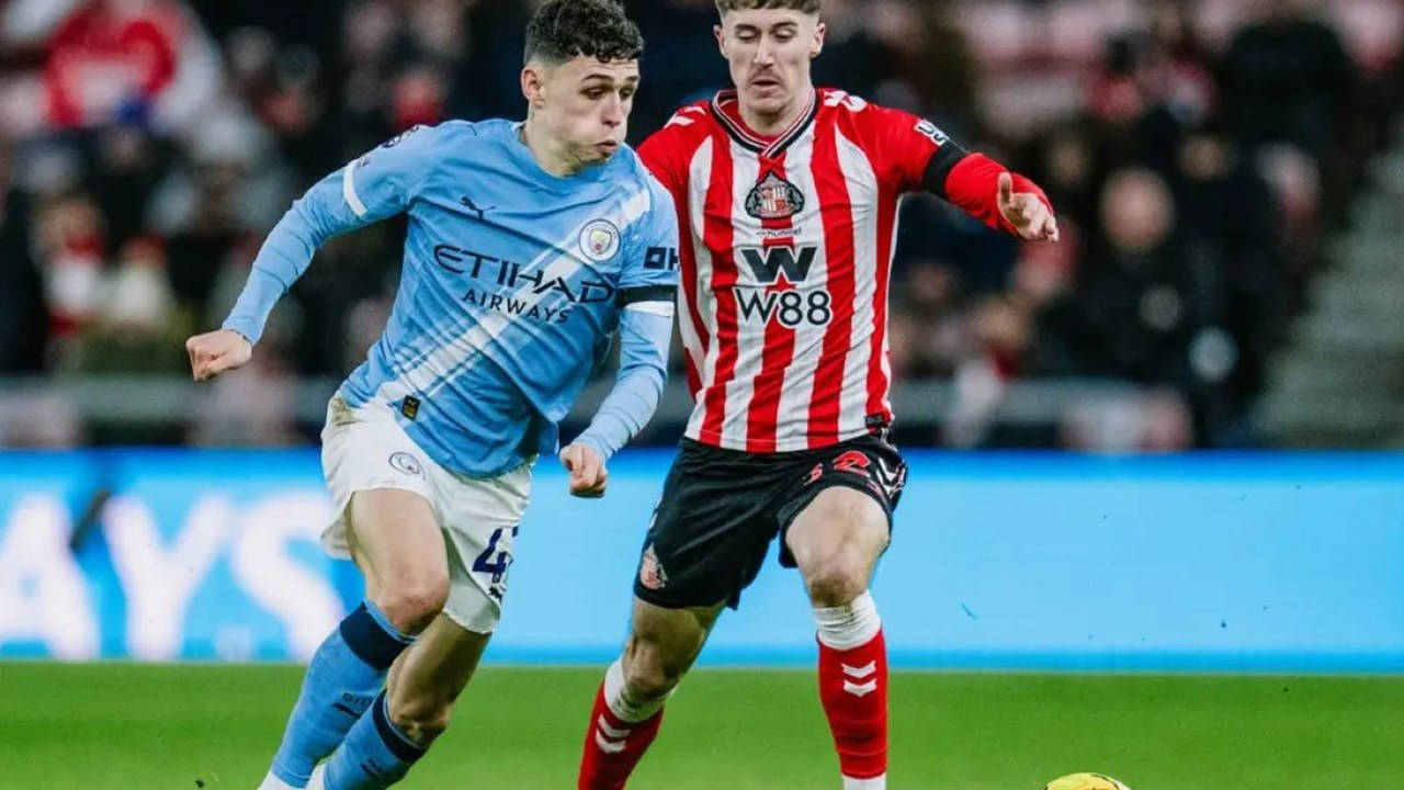 Phil Foden carries the ball beside a Sunderland defender