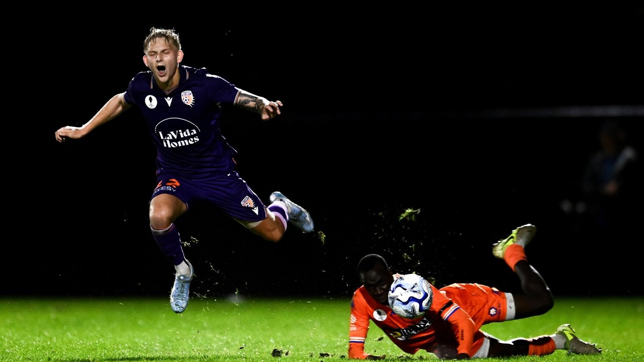 A Perth Glory player falls beside a Lions FC opponent during their Australia Cup match