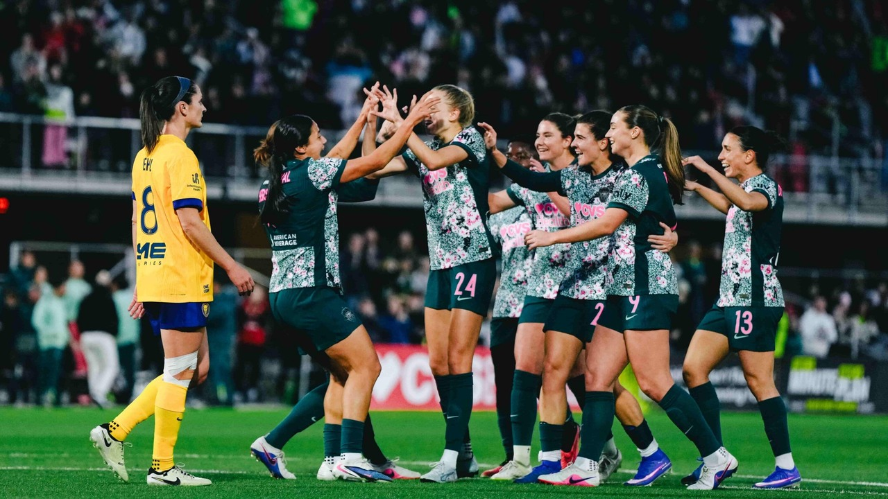 Washington Spirit players celebrate together on the field