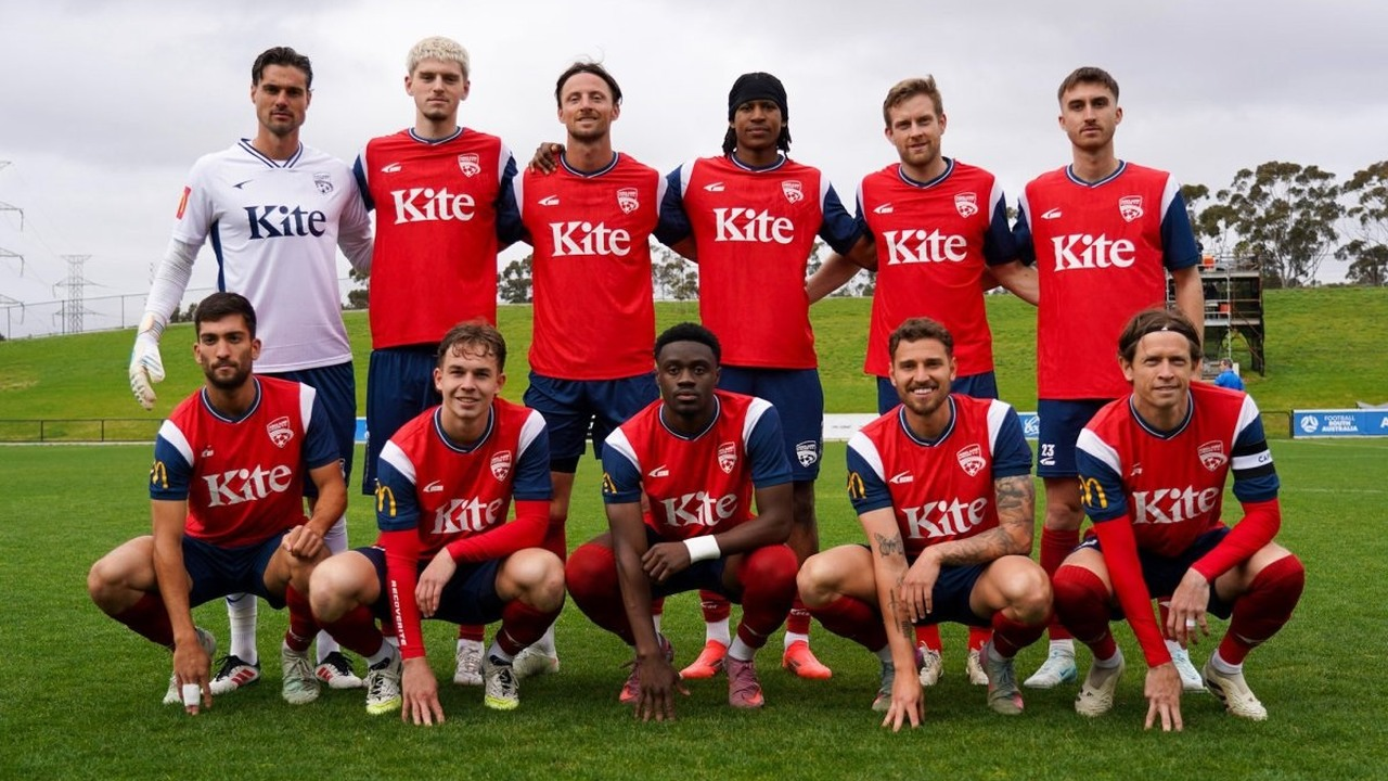 Adelaide United players pose together in red shirts