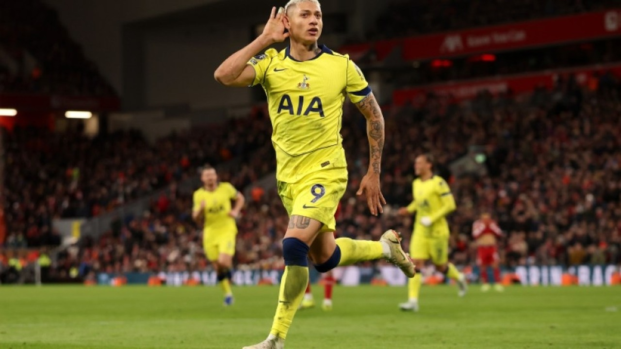 A Tottenham player celebrates a goal in the club's yellow away kit