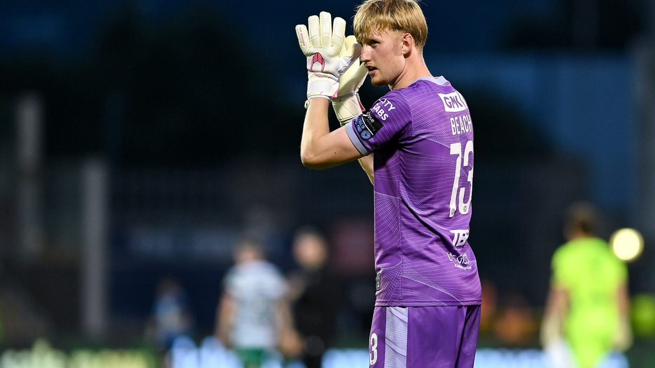 A Shelbourne goalkeeper applauds during a football match