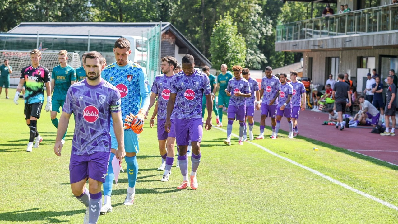 AFC Bournemouth players walk together onto a football pitch