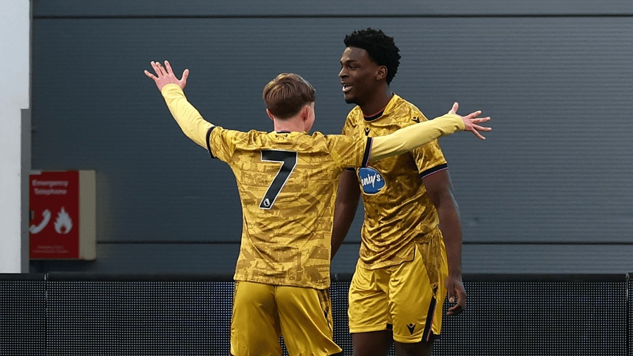Two Brighton youth players celebrate together in gold shirts