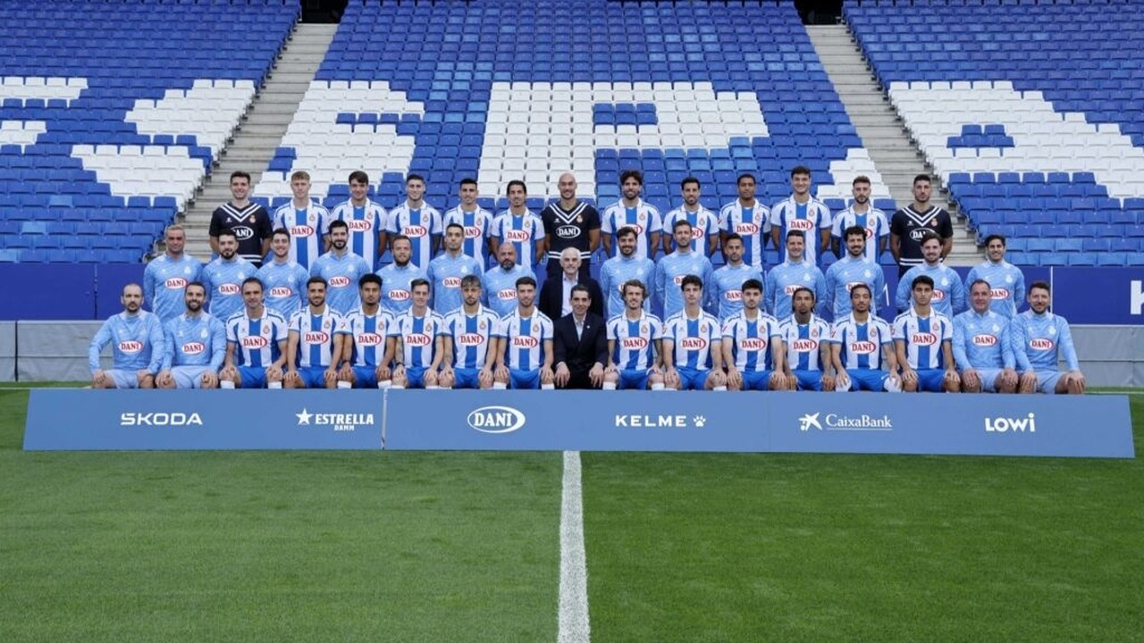 Espanyol players and staff pose together on a football pitch