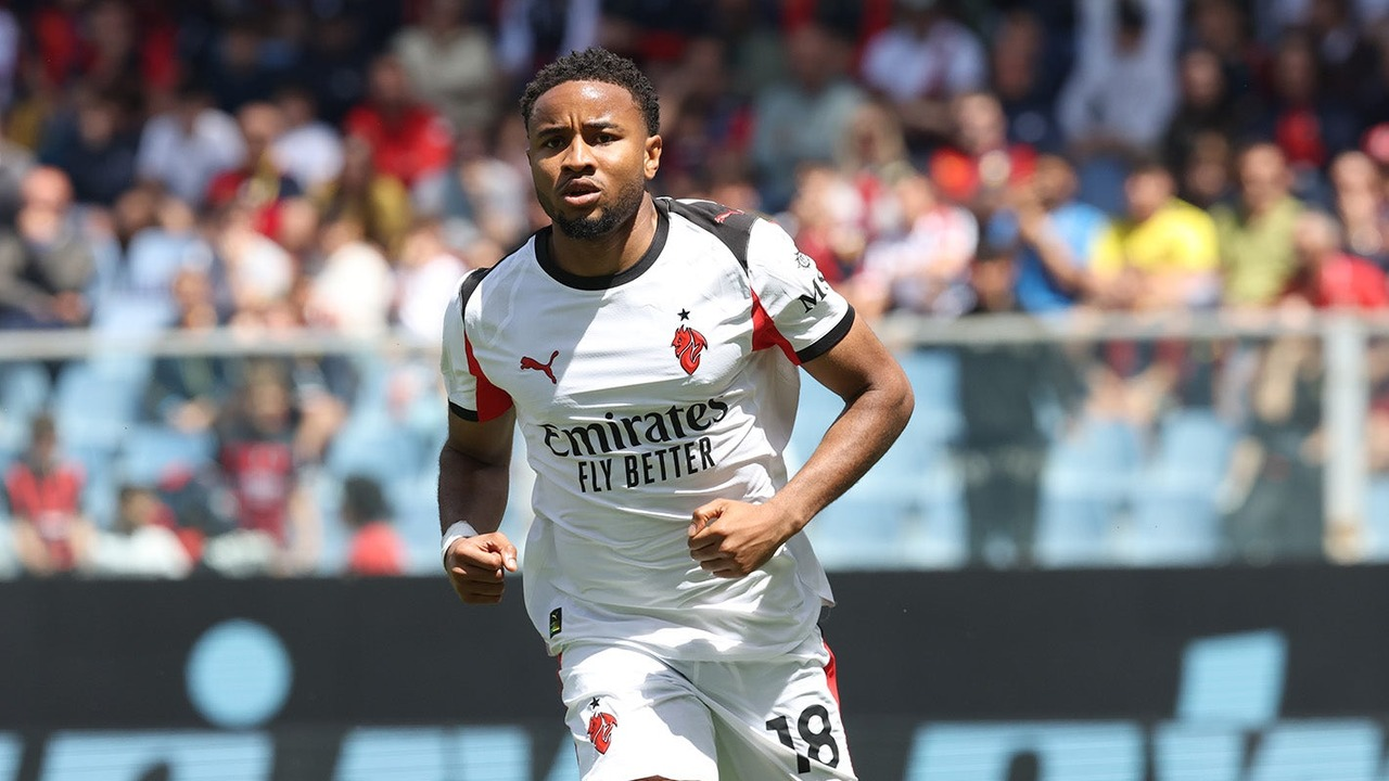 Christopher Nkunku runs in AC Milan's white away kit
