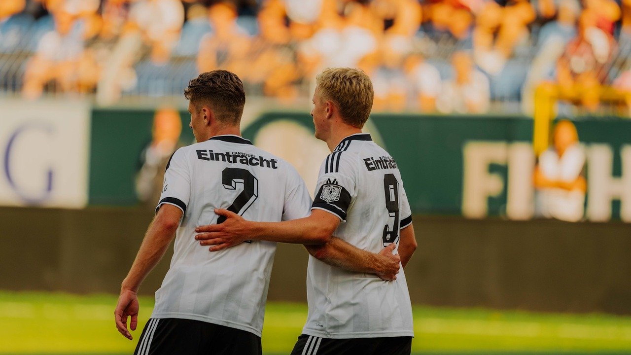 Two Eintracht Frankfurt players walk together after a goal