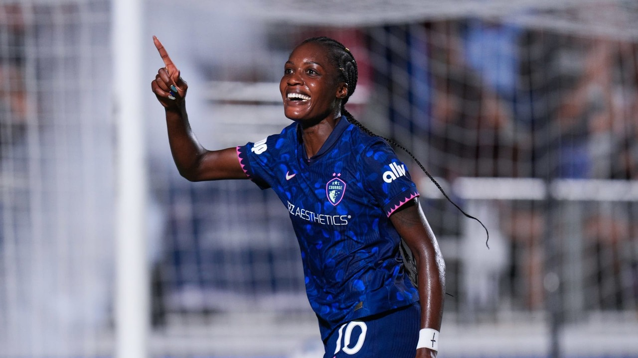 Evelina Ijeh celebrates in a blue North Carolina Courage shirt