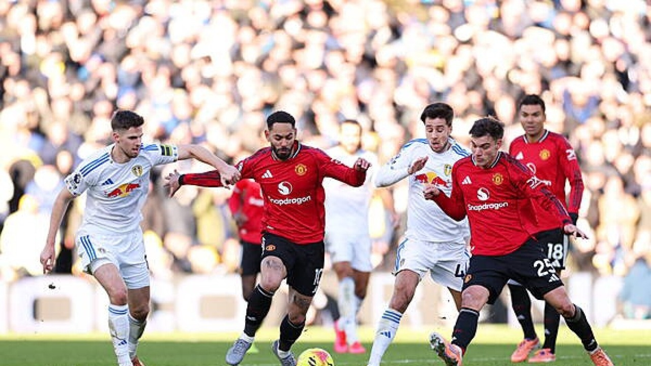 Manchester United and Leeds players walk onto the pitch