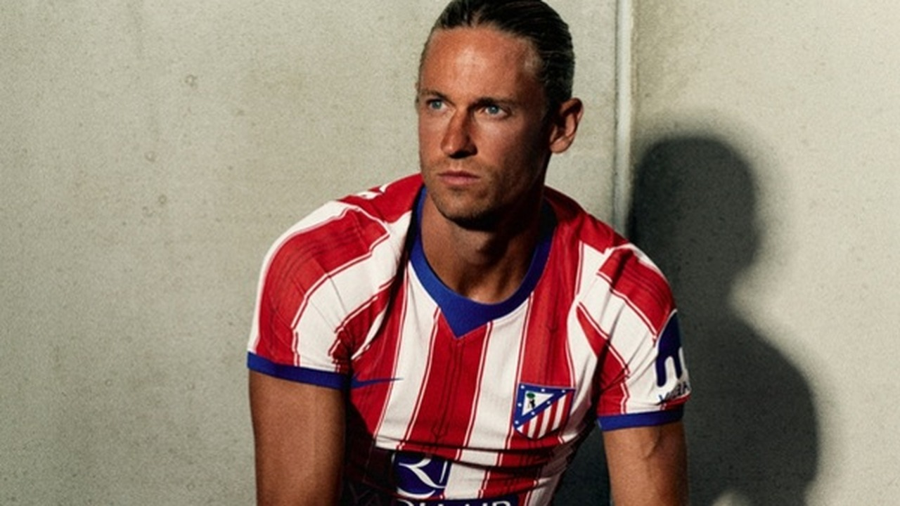 An Atletico Madrid player sits in the club home shirt