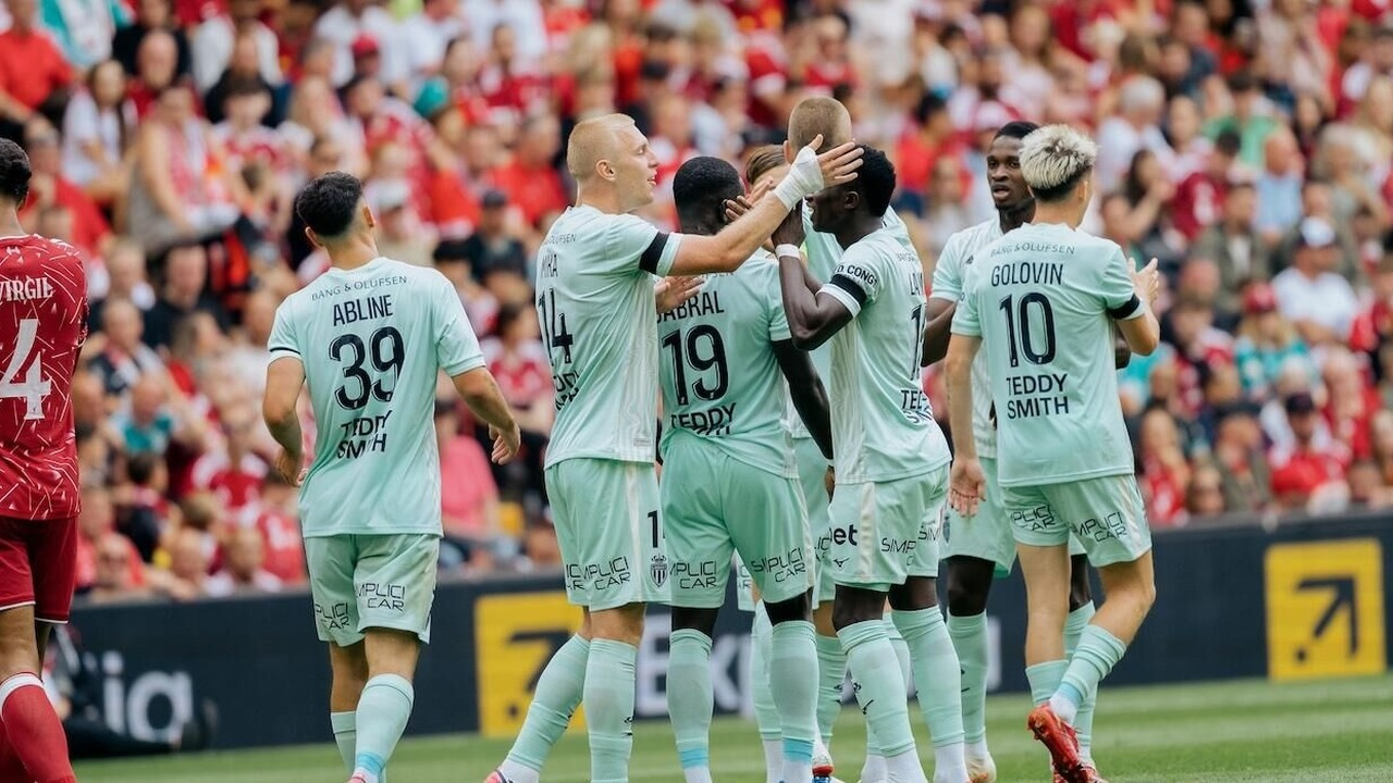 Monaco players gather in a huddle on the pitch