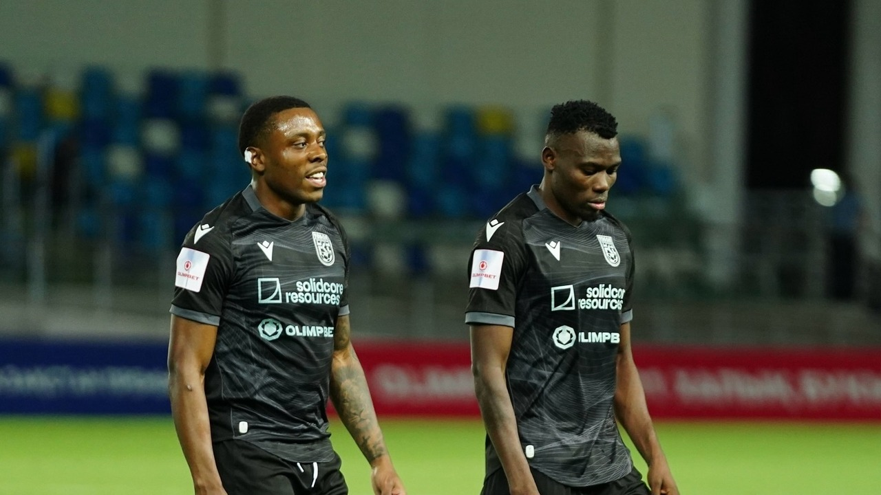 Tobol players stand together on the pitch