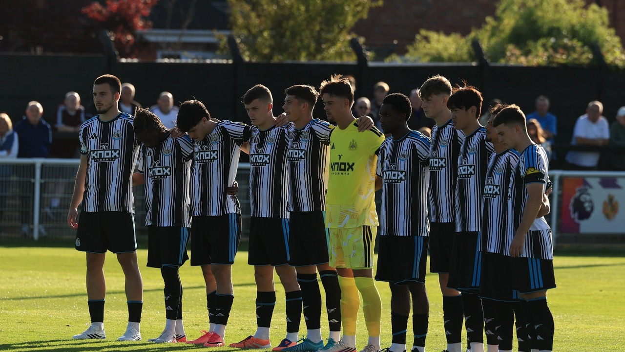 Newcastle United players stand together before the match